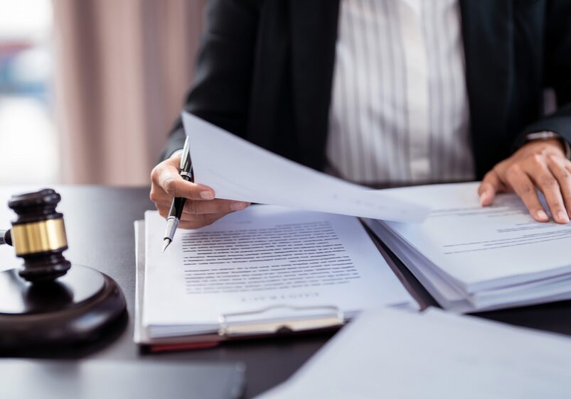 Lawyer,Businesswoman,Holding,Document,To,Reading,Lawsuit,And,Checking,About